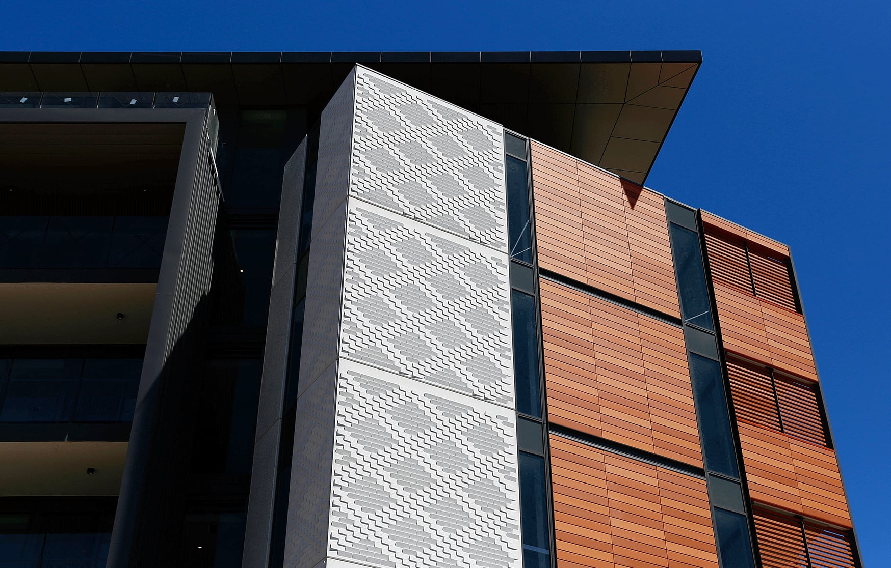 White precast concrete panels with a woven relief pattern wrap the Queenslea building corner in Claremont.